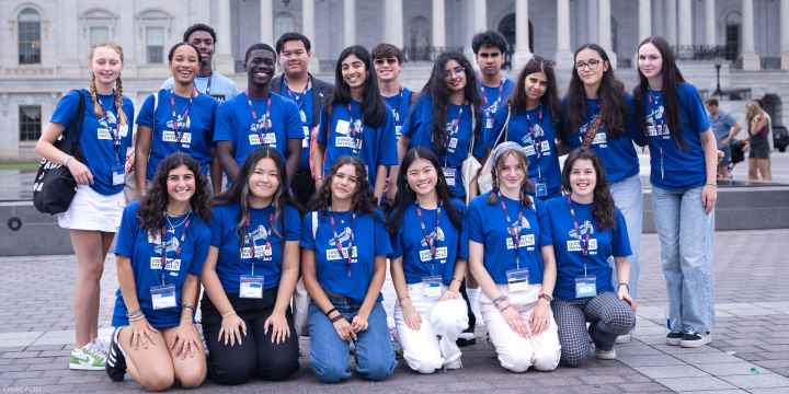 A group of high school students wearing blue shirts reading "DISSENT IS PATRIOTIC" pose for the camera.