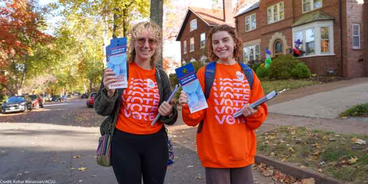 Voter volunteers holding voting pamphlets.