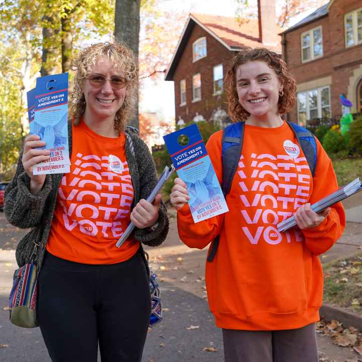 Voter volunteers holding voting pamphlets.